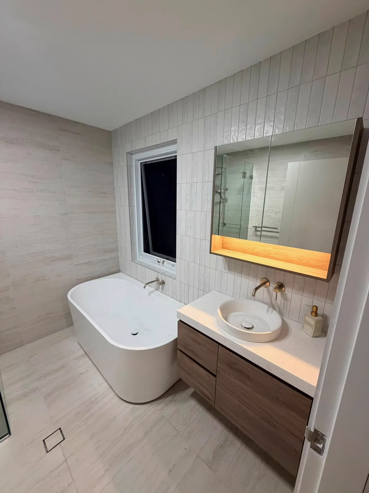Modern bathroom with freestanding bath, timber vanity and vertical tiles, renovation Northern Beaches